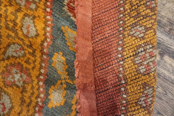 Close-up texture of a richly colored berber rug with orange, blue, and yellow patterns by rugs on net