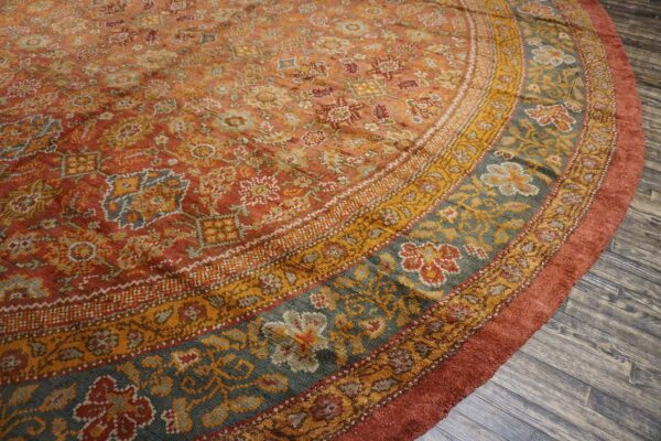 Close-up of a round, richly colored rug featuring intricate floral and geometric patterns in rust, gold, and teal by rugs on net. By rugs on net