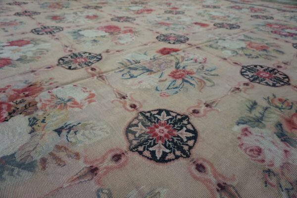 Close-up of a light pink floral needlepoint rug with repeating medallions by rugs on net. By rugs on net