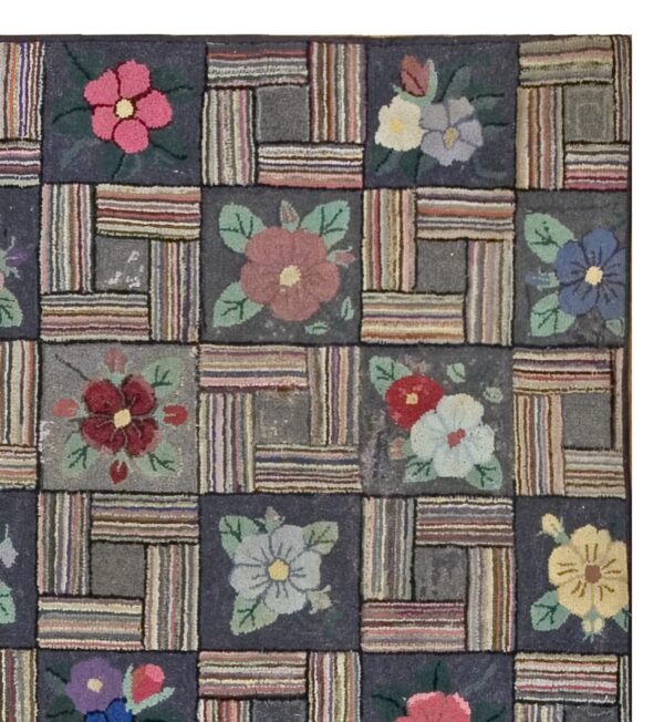 Close-up of a colorful hooked rug featuring a patchwork design with floral squares and striped rectangles, by rugs on net. By rugs on net