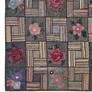 Close-up of a hooked rug featuring a patchwork design with floral motifs in muted pinks, blues, and purples against a dark gray background, by Rugs On Net. by Rugs On Net