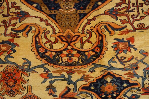 Close-up of a traditional rug pattern featuring intricate floral and curvilinear motifs in orange, blue, and dark accents on a beige field, by rugs on net