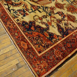Close-up of an antique Persian rug with red and navy accents on a cream field, resting on aged wooden floors, by Rugs On Net
