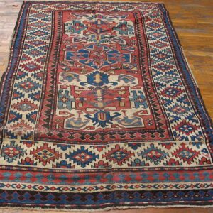 Geometric runner rug with red and blue motifs on a light ground by Rugs On Net