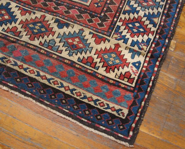 Close-up of geometric patterns in red, blue, and cream on the oriental rug by rugs on net. By rugs on net