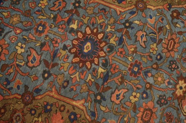 Close-up of a blue field rug with intricate floral patterns in red, gold, and brown by rugs on net. By rugs on net