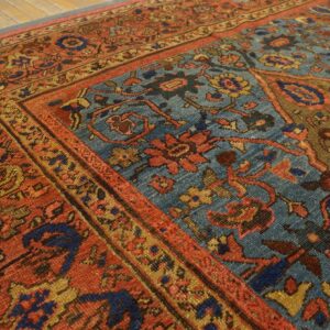 Close-up of an antique rug with rich red and blue tones, showing detailed floral motifs by Rugs On Net. by Rugs On Net