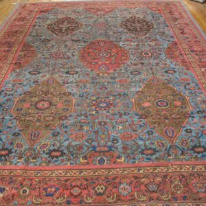 A close-up of a large Persian rug featuring a light blue field with intricate floral patterns and large medallions in red and brown tones, by Rugs On Net. by Rugs On Net
