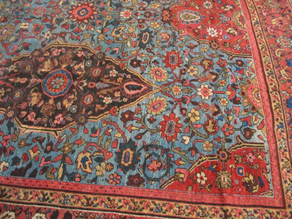 Close-up of a vintage blue and red floral area rug by rugs on net. By rugs on net