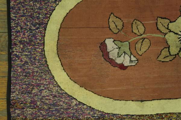 Close-up of a hooked rug detail featuring a floral medallion design in brown and cream, by rugs on net