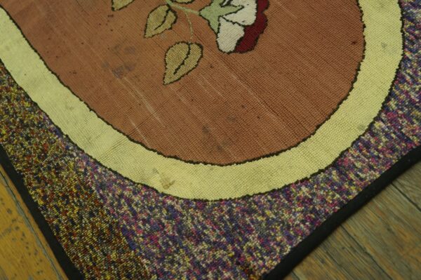 Close-up of a floral hooked rug with brown, cream, and multicolored borders by rugs on net. By rugs on net