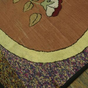 Close-up of a hooked rug featuring a brown field with a floral motif and speckled border, by Rugs On Net