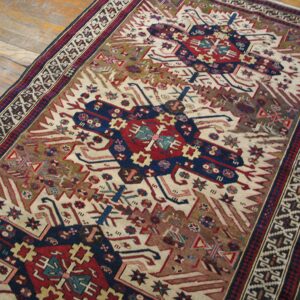 Close-up view of a tribal rug with geometric medallions on a light field by Rugs On Net