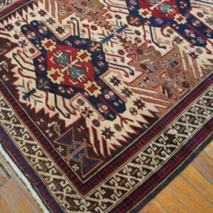 Close-up of a tribal rug with geometric patterns in red, blue, and cream on a wooden floor, by Rugs On Net