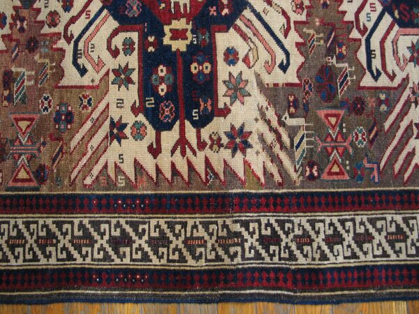 Close-up of tribal motifs and geometric border on the rug by rugs on net. By rugs on net