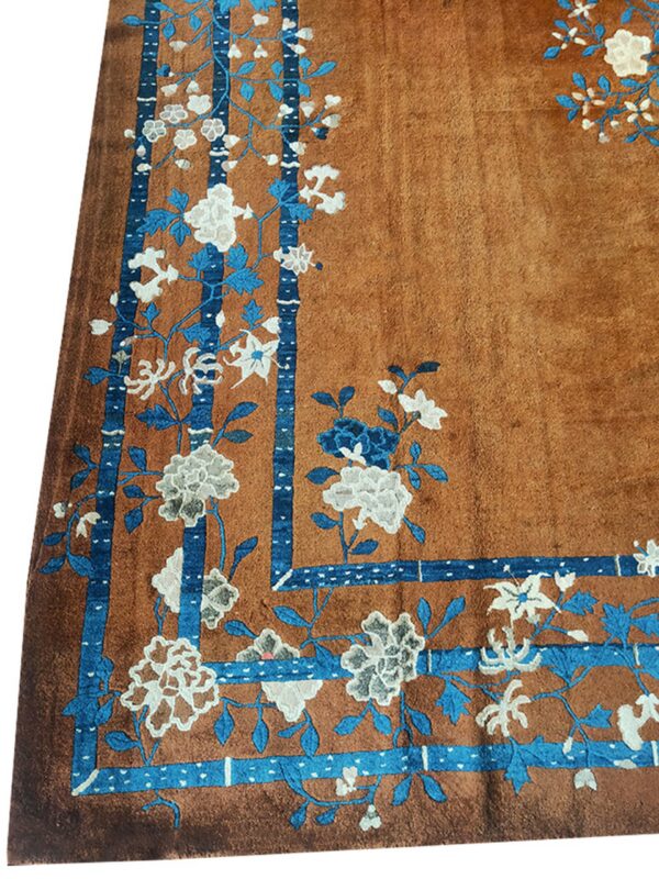 Close-up of a brown rug with blue and white floral border detail, by rugs on net