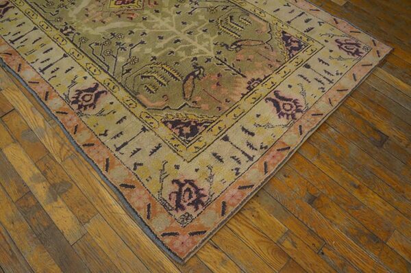 Close-up corner view of an antique rug with olive and cream tones by rugs on net
