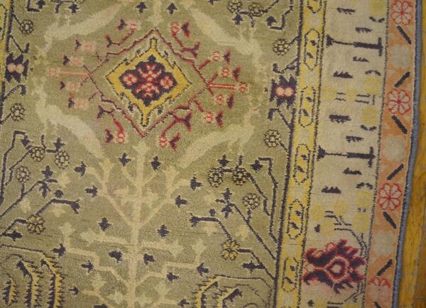 Close-up of an antique green and yellow patterned rug by rugs on net. By rugs on net