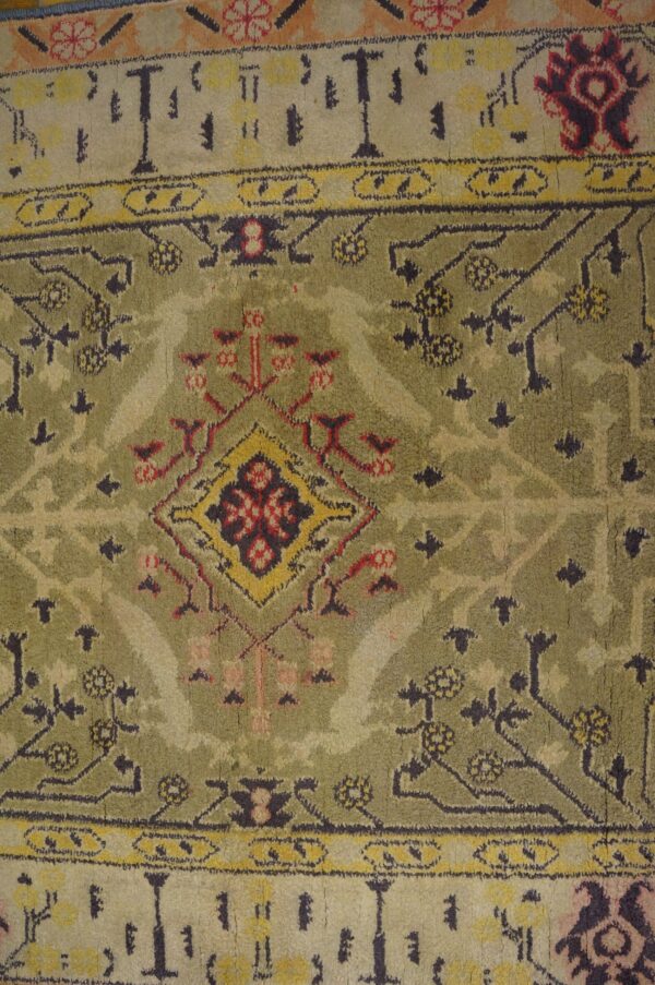 Close-up of a vintage green and cream rug with geometric patterns by rugs on net. By rugs on net