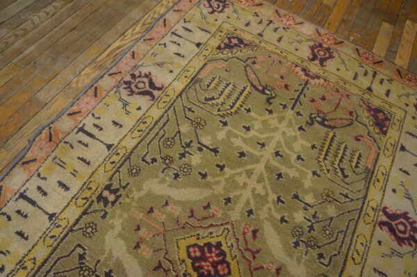 Close-up of an olive green and beige patterned rug on a wooden floor by rugs on net