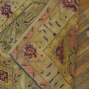 Close-up of a folded vintage rug with olive green and pale yellow accents by Rugs On Net