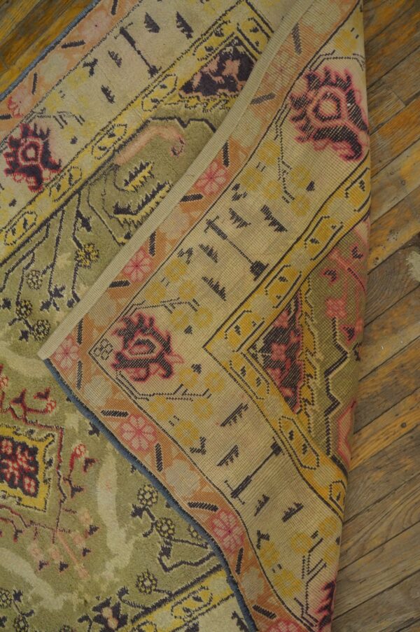 Close-up of a folded vintage rug with olive green and pale yellow accents by rugs on net