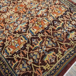 Close-up of a dark brown field rug with intricate floral patterns in orange, blue, and yellow by Rugs On Net