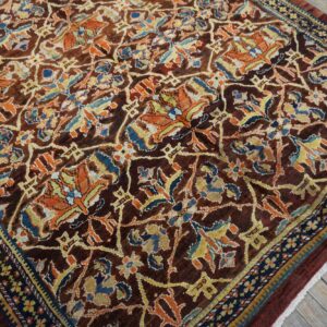Close-up of a dark brown field rug with intricate orange and blue floral patterns by Rugs On Net