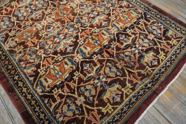 Close-up of a dark brown field rug with intricate orange and blue floral patterns by rugs on net