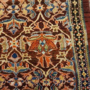 Close-up of a richly colored, dark brown rug featuring intricate floral and geometric patterns in orange, blue, and yellow, by Rugs On Net. by Rugs On Net