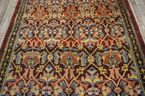 Close-up of an antique rug with rich brown, orange, and blue floral patterns by rugs on net