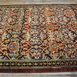 Close-up of a richly colored antique rug with intricate floral patterns on a dark brown field, by Rugs On Net