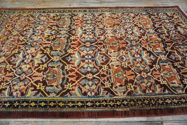 Close-up of a richly colored antique rug with intricate floral patterns on a dark brown field, by rugs on net