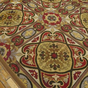 Close-up of a richly patterned rug with red, gold, and brown tones, featuring ornate medallion motifs, by Rugs On Net. by Rugs On Net