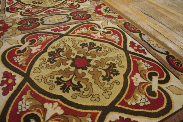 Close-up of a colorful aubusson style rug with intricate medallions and floral motifs on a light wood floor by rugs on net