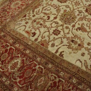 Close-up of a traditional rug featuring cream field with floral motifs and a deep red border, by Rugs On Net