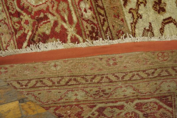 Close-up of the fringe and backing of a traditional red and beige rug by rugs on net. By rugs on net