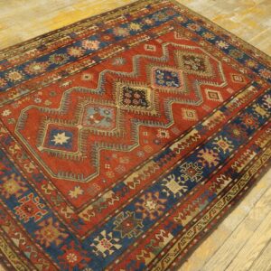 Close-up of a richly colored antique rug with geometric patterns in red and blue by Rugs On Net. by Rugs On Net