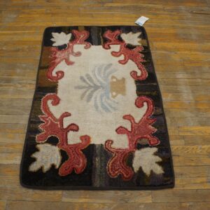 A hooked rug with a cream center, red scrollwork border, and dark edges, resting on a wooden floor, by Rugs On Net