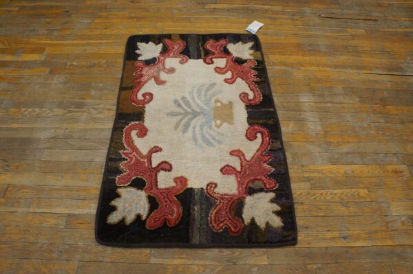 A hooked rug with a cream center, red scrollwork border, and dark edges, resting on a wooden floor, by rugs on net