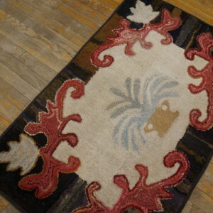 A close-up of a colorful hooked rug with a central cream area and red scrollwork border, by Rugs On Net. by Rugs On Net