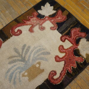 Close-up of a colorful hooked rug with red scrollwork on a cream field, by Rugs On Net