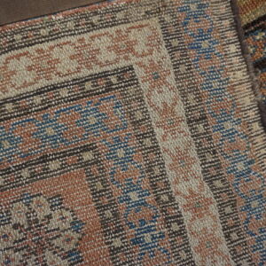 Close-up of a woven kilim with geometric patterns in rust, blue, and beige by Rugs On Net
