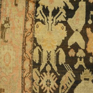 Close-up detail of a tribal rug border with geometric shapes in muted pink, beige, and dark brown, by Rugs On Net