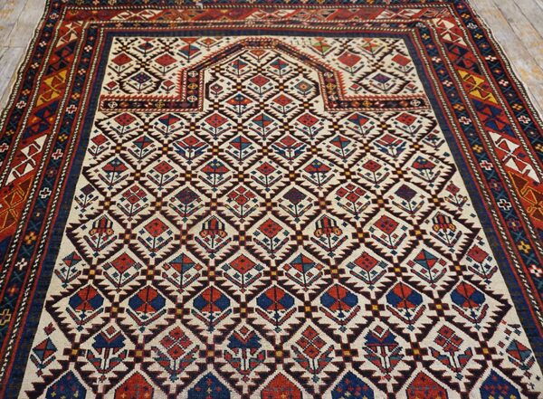 Close-up of a tribal rug with geometric motifs in red, blue, and cream, by rugs on net. By rugs on net