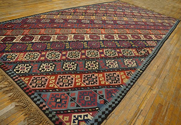 Colorful striped kilim rug with geometric patterns laid on a wooden floor by rugs on net