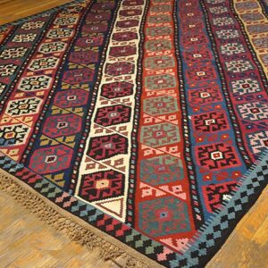 A vibrant striped kilim rug with geometric patterns on a wooden floor by Rugs On Net. by Rugs On Net