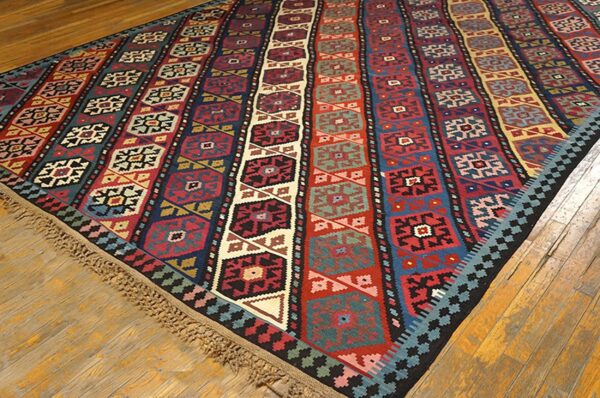 A vibrant striped kilim rug with geometric patterns on a wooden floor by rugs on net. By rugs on net