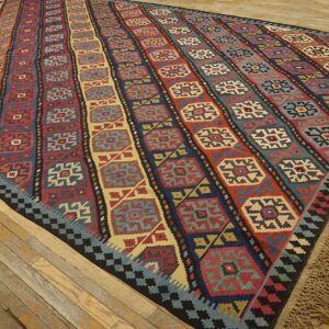 Colorful striped kilim rug with geometric medallions on a wooden floor by Rugs On Net