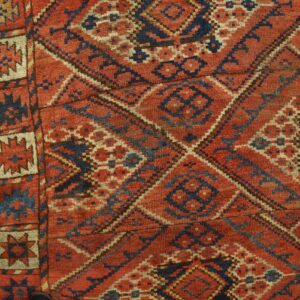 Close-up of a richly textured, antique rug with geometric patterns in red, blue, and cream, by Rugs On Net. by Rugs On Net